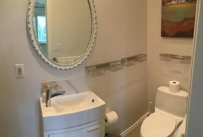 a white bathroom with a sink and a mirror at Vineyard Villa in Niagara on the Lake