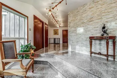 a lobby with a table and a stone wall at Vineyard Villa in Niagara on the Lake