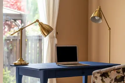 a laptop sitting on a blue desk with a lamp at 4br Near Hilton Falls - Kelso - Gazebo, Workspace in Milton