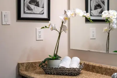a bathroom sink with a basket of towels and flowers at 4br Near Hilton Falls - Kelso - Gazebo, Workspace in Milton
