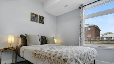 a bedroom with a bed and a large window at 2br Boho Townhouse - Walk To Falls, Free Parking in Niagara Falls