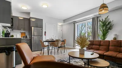 a living room with a couch and a table at 2br Boho Townhouse - Walk To Falls, Free Parking in Niagara Falls