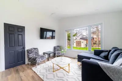 a living room with a blue couch and a table at 2br - Spacious Yard - Canal Bridge, Falls Nearby! in Welland