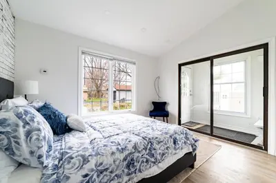 a white bedroom with a bed and a window at 2br - Spacious Yard - Canal Bridge, Falls Nearby! in Welland
