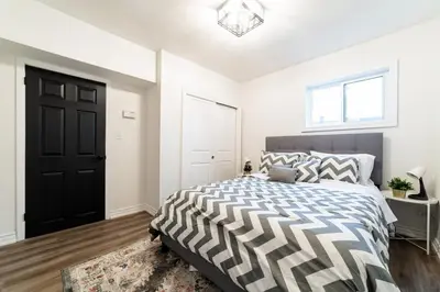 a bedroom with a bed and a black door at 2br - Spacious Yard - Canal Bridge, Falls Nearby! in Welland
