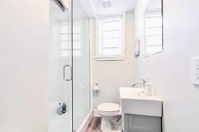 a white bathroom with a toilet and a shower at Modern Apartment in Corktown Hamilton Sleeps 4 in Hamilton