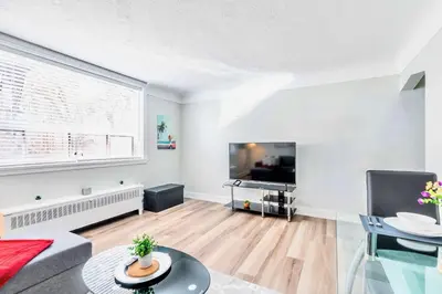 a living room with a large window and a flat screen tv at Modern Apartment in Corktown Hamilton Sleeps 4 in Hamilton