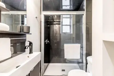a bathroom with a shower and a toilet and a sink at Modern Apartment in a Trendy Neighbourhood in Hamilton