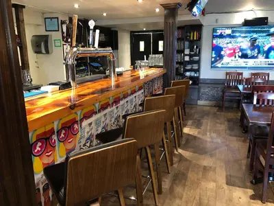 a restaurant with a bar with chairs and a large screen at Modern Apartment in a Trendy Neighbourhood in Hamilton