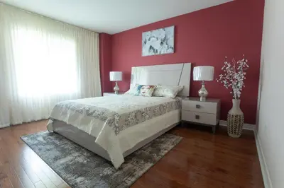 a bedroom with a bed and a red wall at Main Floor Luxury Apartment in Vaughan