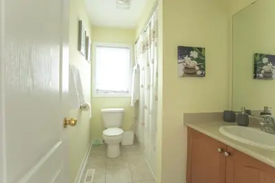 a bathroom with a toilet and a sink at Main Floor Luxury Apartment in Vaughan