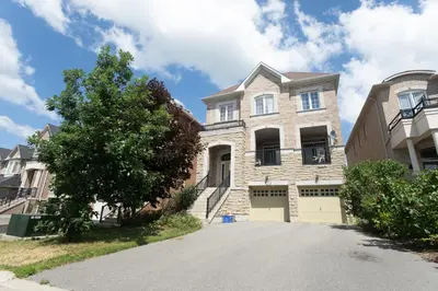 a large brick house with a driveway at Main Floor Luxury Apartment in Vaughan