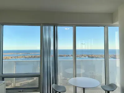 a room with large windows with a table and chairs at Presidential Suite Heart of Downtown with Stunning View in Toronto