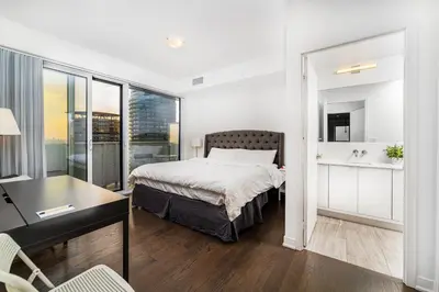 a bedroom with a bed and a desk and a room with a window at Presidential Suite Heart of Downtown with Stunning View in Toronto
