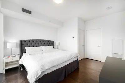 a white bedroom with a large bed with white sheets at Presidential Suite Heart of Downtown with Stunning View in Toronto