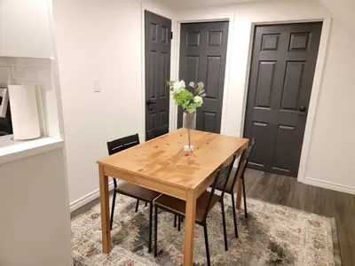 a dining room table with a vase of flowers on it at 2br, Welland Canal, Near Merritt, 20 Min To Falls in Welland