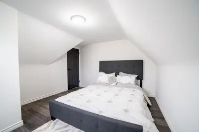 a bedroom with a large bed with white walls at 2br, Welland Canal, Near Merritt, 20 Min To Falls in Welland