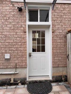 a white door on the side of a brick building at Spacious Bottom-Floor 2BR Suite in Innisfil