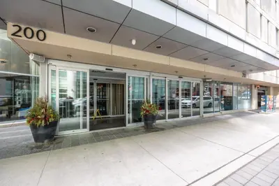 a building with two potted plants in front of it at Modern 2-Bedroom Condo w Floor to Ceiling Windows in Toronto