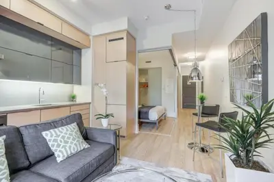 a living room with a couch and a kitchen at Metropolis Loft - CN Tower in Toronto
