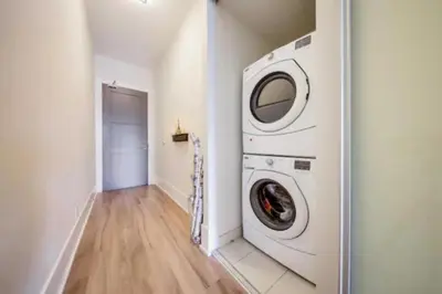 a washer and dryer in a white laundry room at Metropolis Loft - CN Tower in Toronto