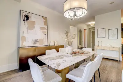 a dining room with a table and white chairs at Metropolis Loft - CN Tower in Toronto