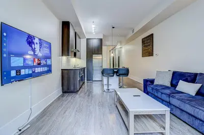 a living room with a blue couch and a table at Metropolis Loft - CN Tower in Toronto