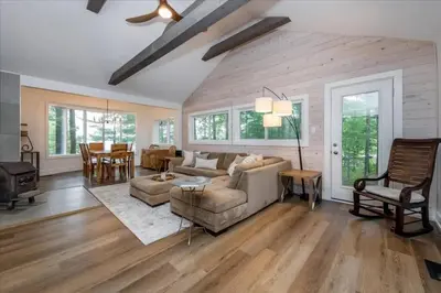 a living room with a couch and a table at Gorgeous Muskokan Cottage on Six Mile Lake in Port Severn