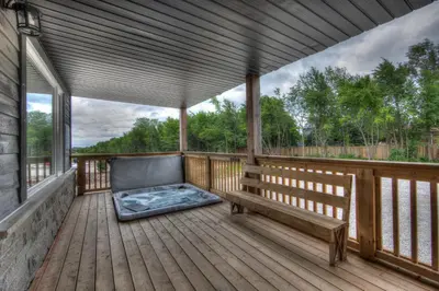 a large porch with a bench on a wooden deck at Luxury Cottage at Blue Mountain, Private Beach Access, BBQ, Hot Tub, 7 baths in Blue Mountains