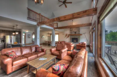a living room with leather furniture and a fireplace at Luxury Cottage at Blue Mountain, Private Beach Access, BBQ, Hot Tub, 7 baths in Blue Mountains