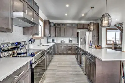 a large kitchen with wooden cabinets and stainless steel appliances at Luxury Cottage at Blue Mountain, Private Beach Access, BBQ, Hot Tub, 7 baths in Blue Mountains