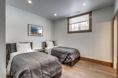 a bedroom with two beds and a window at Luxury Cottage at Blue Mountain, Private Beach Access, BBQ, Hot Tub, 7 baths in Blue Mountains