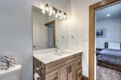 a bathroom with a sink and a mirror at Luxury Cottage at Blue Mountain, Private Beach Access, BBQ, Hot Tub, 7 baths in Blue Mountains