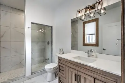 a bathroom with a sink and a toilet and a shower at Luxury Cottage at Blue Mountain, Private Beach Access, BBQ, Hot Tub, 7 baths in Blue Mountains