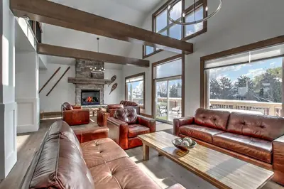 a living room with leather furniture and a fireplace at Luxury Cottage at Blue Mountain, Private Beach Access, BBQ, Hot Tub, 7 baths in Blue Mountains