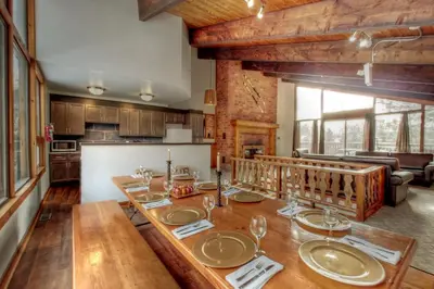 a dining room with a table with wine glasses on it at 8 bdrm Blue Mountain Cottage, Large Groups, Private Beach Access, Hot Tub, Sauna, Ping Pong Table Perfect for Large Groups, Petfriendly in Blue Mountains