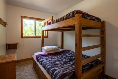 a bedroom with two bunk beds in a house at 4 Bedroom Cottage near The Village, Private Beach Access, BBQ, Petfriendly in Blue Mountains