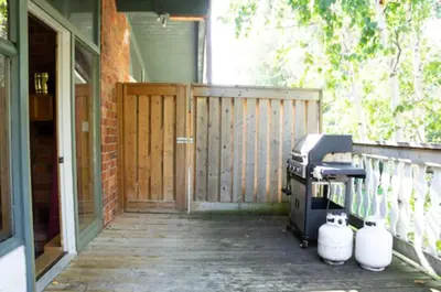 a front porch with a grill and a door at 4 Bedroom Cottage near The Village, Private Beach Access, BBQ, Petfriendly in Blue Mountains