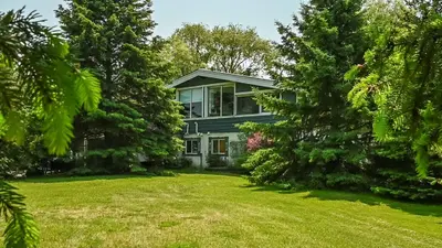 a large house with trees in front of it at 4 Bedroom Cottage near The Village, Private Beach Access, BBQ, Petfriendly in Blue Mountains
