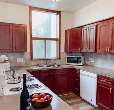 a kitchen with wooden cabinets and a bowl of fruit at 6 bdrm Blue Mountain Cottage, Private Beach Access, Hot Tub, Sauna, Table Tennis, BBQ, Petfriendly in Blue Mountains