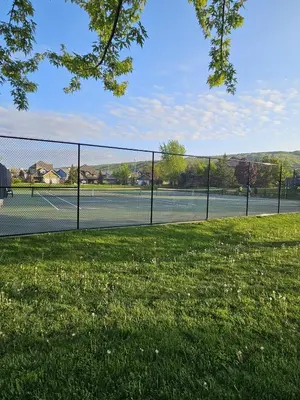 a tennis court with a fence and grass at 4 Bedroom Condo at Tyrolean at Blue Mountain in Blue Mountains