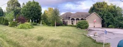 a house with a large yard in front of it at Khan’s Resort in Cobourg