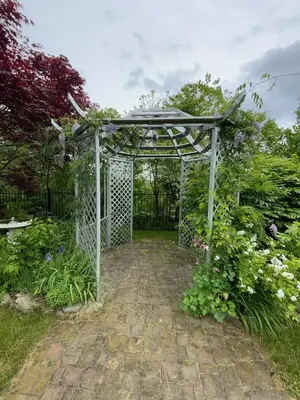a metal gate in a garden with flowers at Khan’s Resort in Cobourg