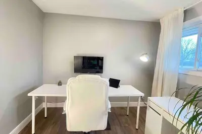a room with a white desk with a computer on it at White House Suite - Sleeps 4 in St. Catharines