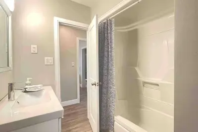 a white bathroom with a sink and a shower at White House Suite - Sleeps 4 in St. Catharines