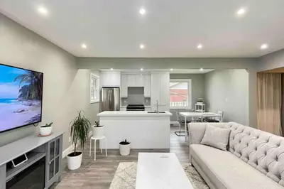 a living room with a couch and a kitchen at White House Suite - Sleeps 4 in St. Catharines