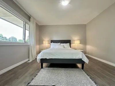 a bedroom with a bed and a large window at Mountain View Suite - Sleeps 6 in St. Catharines
