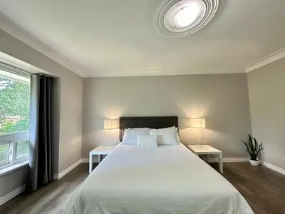 a bedroom with a large bed with two tables and two lamps at Mountain View Suite - Sleeps 6 in St. Catharines