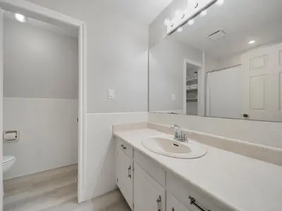 a white bathroom with a sink and a mirror at The Captains Lake House in Orillia