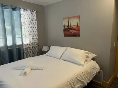 a white bed with a roll of toilet paper on it at Lovely Muskoka Waterfront Cottage-Hot tub & Sauna! in Bracebridge